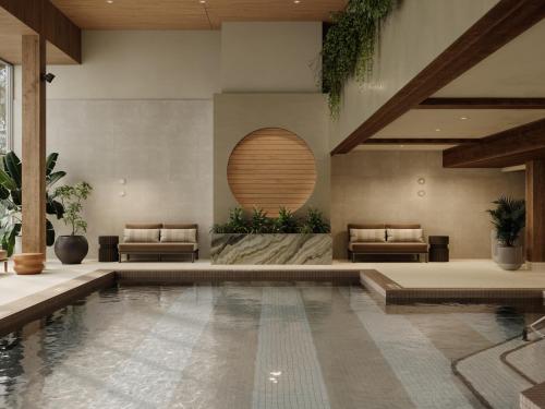 a swimming pool in a building with two chairs at The Kenrick Hotel in Banff