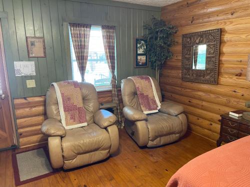 two chairs and a bed in a bedroom at Mountain Aire Cottages, Inn, & Glamping in Clayton