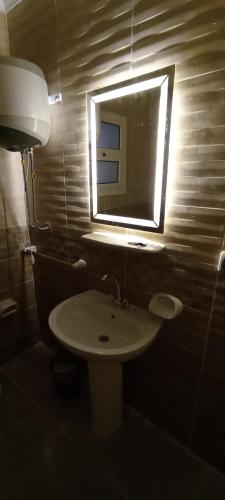 a bathroom with a sink and a mirror at 2BD prime apartment in rehab city in New cairo