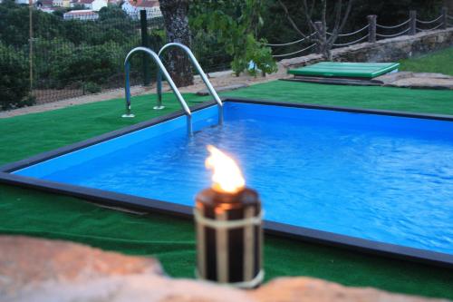 a lit candle in front of a swimming pool at Casas do Bairrinho in Sambade