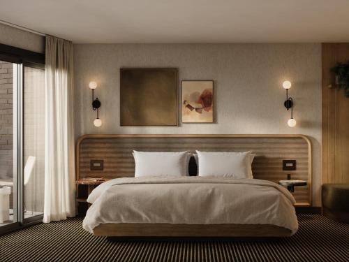 a bedroom with a large bed with white pillows at The Kenrick Hotel in Banff