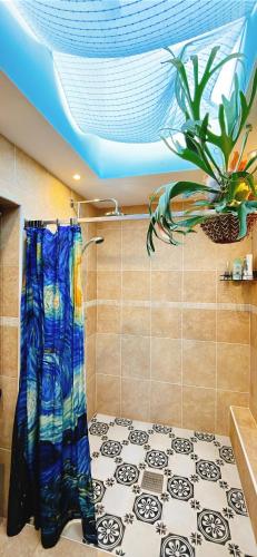 a bathroom with a shower curtain and a potted plant at Funky Urban Jungle in Cardiff