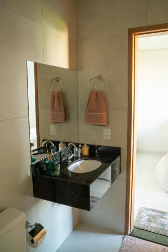 a bathroom with a sink and a mirror at Alvorada do Lago - A melhor hospedagem de Umuarama in Umuarama