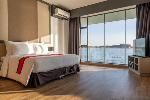 a hotel room with a bed and a large window at Pan Ville Resort in Pathum Thani