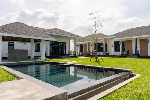 a swimming pool in the yard of a house at Pan Ville Resort in Pathum Thani