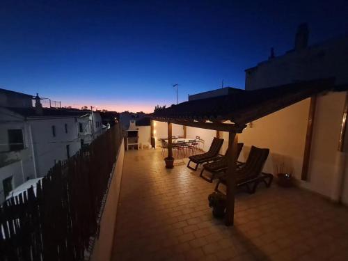 a patio with chairs and a table on a balcony at Linas Guesthouse in Parchal
