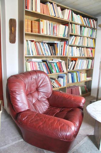 a brown leather chair sitting in front of a book shelf at Kackelstugan in Borgholm