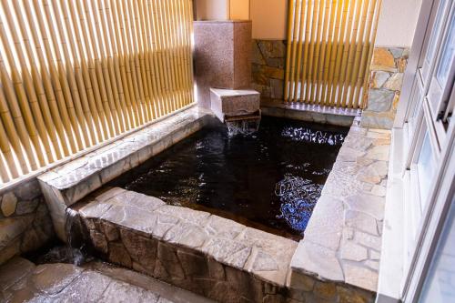 a koi pond in front of a building at Natural Hot Spring Ariston Hotel Oita in Oita