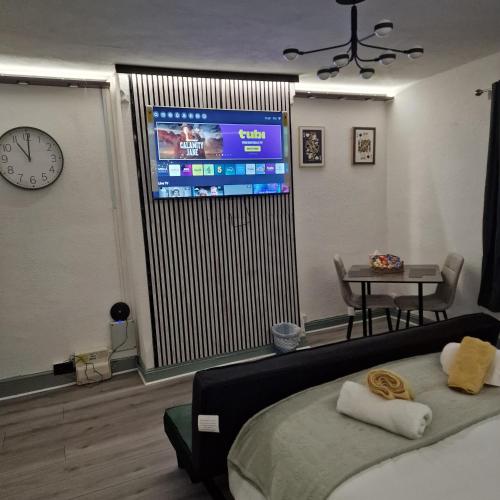 a bedroom with a bed and a large screen television at Balco Strata Studio in Nottingham