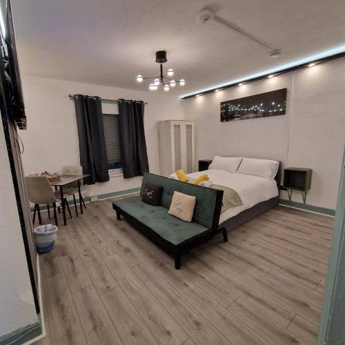 a bedroom with a bed and a couch and a table at Balco Strata Studio in Nottingham