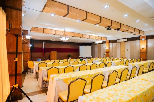 a conference room with yellow tables and chairs at Boracay Tropics Resort Hotel in Boracay