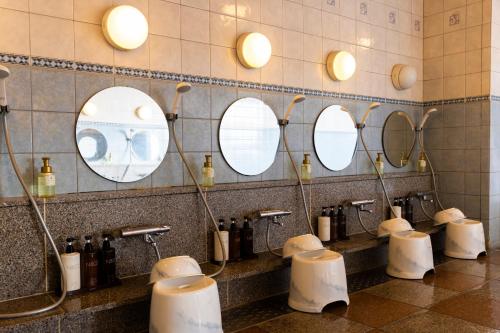 a bathroom with a row of sinks and mirrors at Natural Hot Spring Ariston Hotel Oita in Oita