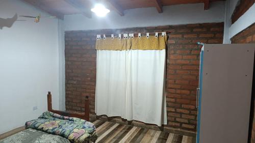 a bedroom with a bed and a white curtain at Casa del Pié del Cerro in San José
