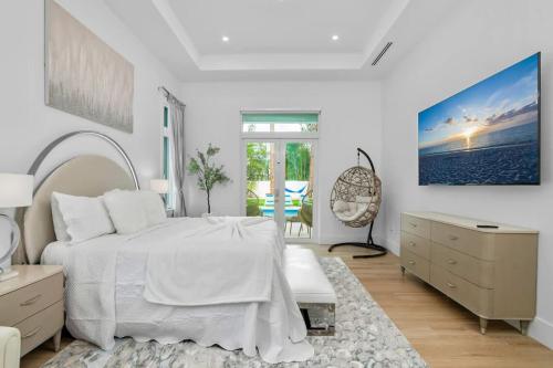 a white bedroom with a bed and a dresser at Blue Diamond Beach Home in Bonita Springs
