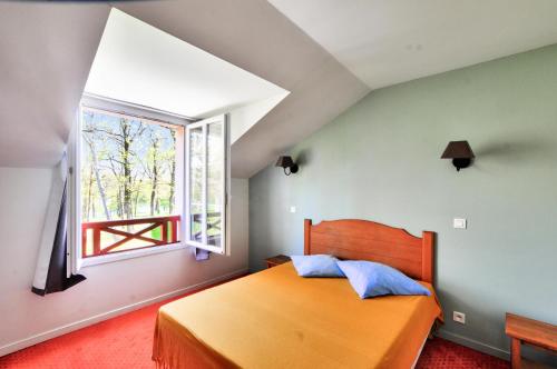 - une chambre avec un grand lit orange et une fenêtre dans l'établissement La résidence du Lac - maeva Home - Appartement 2 pièces 5 personnes - Sélection MAE-3921, à Monflanquin