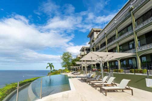 a hotel with a swimming pool next to the ocean at 360 Splendor 208A- Ocean View Condo, Breakfast in Playa Flamingo