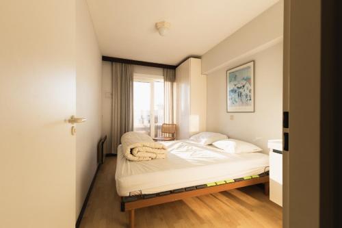 a small bedroom with a bed with a window at Cadiz 0602 in Sint-Idesbald