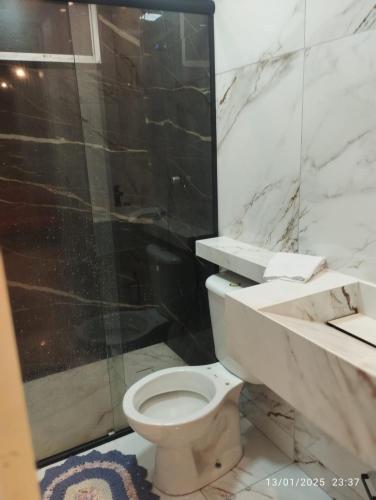 a bathroom with a toilet and a glass shower at Mi casa su casa 5 in Londrina