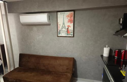 un divano in una stanza con un quadro della Torre Eiffel di Edificio Bellini a Santa Cruz de la Sierra