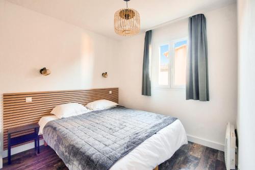 une chambre avec un grand lit et une fenêtre dans l'établissement Les Coteaux de Pont Royal en Provence - maeva Home - Appartement 3 pièces 6 personnes - Prestige MAE-6331, à Mallemort