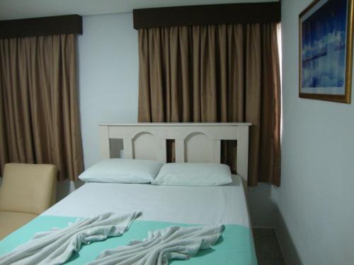 a bedroom with a bed with two white pillows at D'arc Hotel in Goiânia
