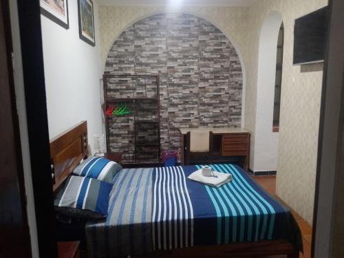 a bedroom with a bed and a stone wall at Hotel Lider in Santa Cruz de la Sierra