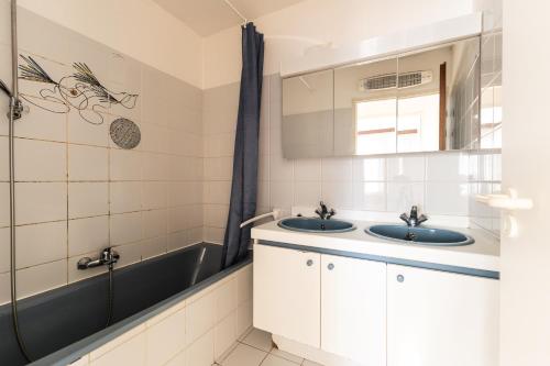a bathroom with two sinks and a bath tub at Cadiz 0602 in Sint-Idesbald
