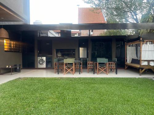 a house with a patio with chairs and tables at Punta Chica - Alojamiento Premium in Victoria