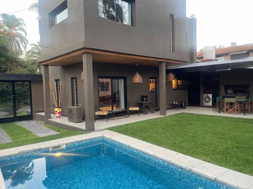 a house with a swimming pool in front of a house at Punta Chica - Alojamiento Premium in Victoria