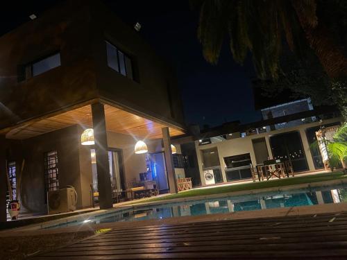 a house with a swimming pool at night at Punta Chica - Alojamiento Premium in Victoria