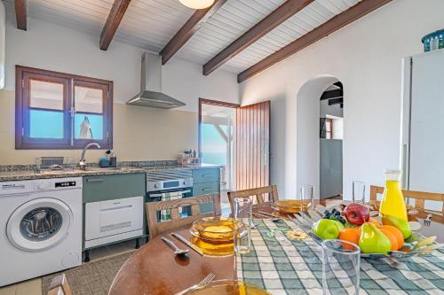 a kitchen and dining room with a table with fruit on it at Vila Pitaias in Estreito da Calheta