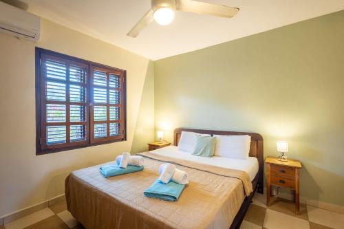 a bedroom with a bed with two towels on it at Elegant Getaway for Couples & Friends at Blue Bay in Willemstad