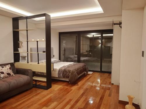 a bedroom with a bed and a couch at Nuevo departamento de lujo céntrico Zona Obrajes in La Paz