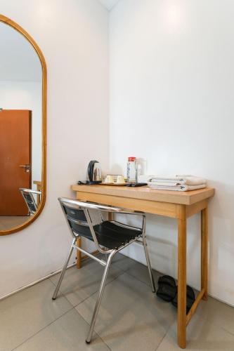 a desk with a chair next to a mirror at Djajanti House in Semarang