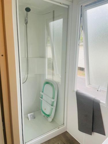 - une salle de bains pourvue d'un siège bleu dans la fenêtre dans l'établissement Mobil-home 3 chambres, Plage & piscine, camping 4 étoiles, à Torreilles