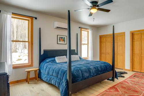 a bedroom with a bed with a blue comforter and a fan at Stratton Mtn Ski Chalet with Giant Views in Winhall in Stocker Acres