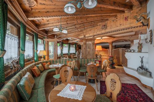 フィエーラ・ディ・プリミエーロにあるBrunet - The Dolomites Resortのソファ、テーブル、椅子が備わる客室です。