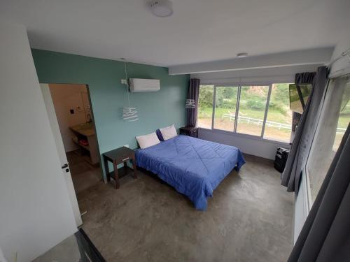 ein Schlafzimmer mit einem blauen Bett und einem Fenster in der Unterkunft Casa Bella Vista in San Salvador de Jujuy