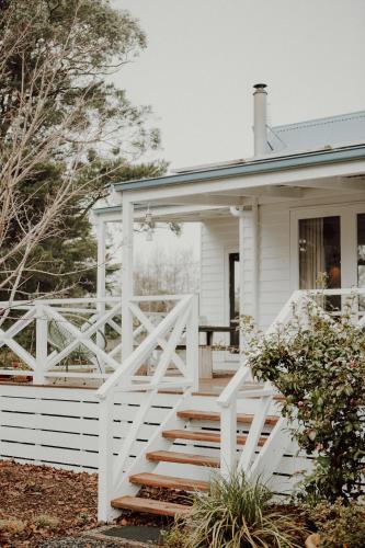a white house with a white fence at Birch Cottage Trentham in Trentham