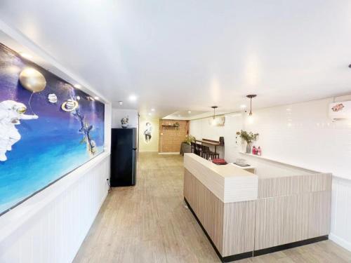 an office lobby with a reception desk and a large painting at Youjia Youth Hostel in Bang Rak