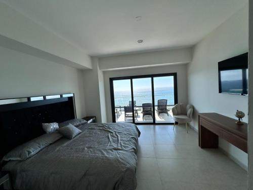 a bedroom with a bed and a view of the ocean at Altomare Depa 1804 in Mazatlán