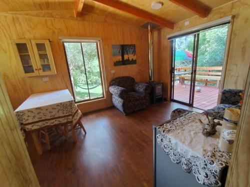 ein Zimmer mit einem Wohnzimmer mit einem Tisch und Stühlen in der Unterkunft Entre Aromos in Lago Ranco