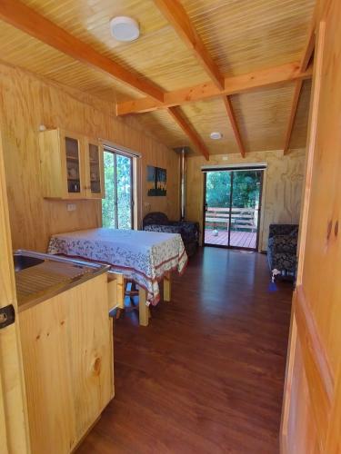 ein Schlafzimmer mit einem Bett in einem Holzhaus in der Unterkunft Entre Aromos in Lago Ranco