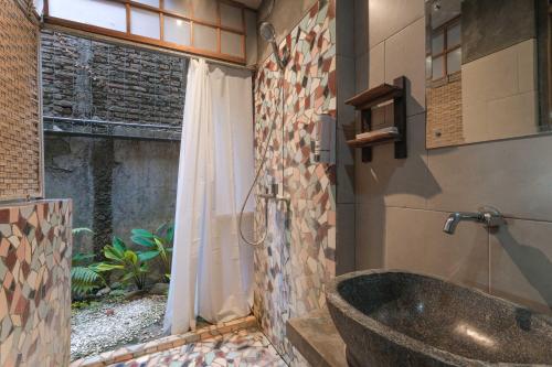 a bathroom with a large stone tub in the corner at Djajanti House in Semarang