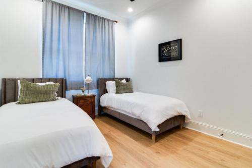 ein Schlafzimmer mit zwei Betten und einem Fenster in der Unterkunft Cajun Country Retreat King Beds Patio Arcade Luxe in Lafayette