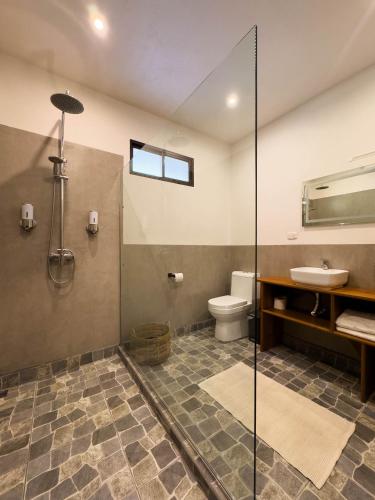 a bathroom with a shower and a toilet and a sink at Finca Aquarius in Monteverde Costa Rica
