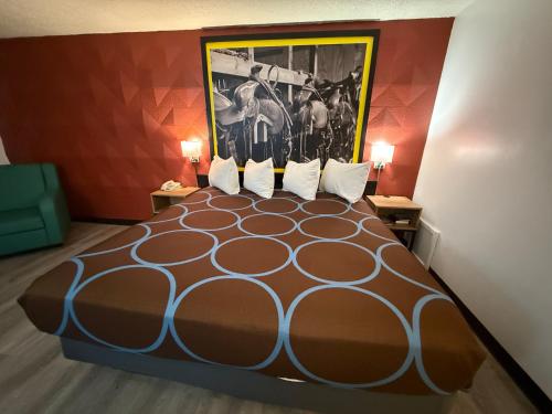 a hotel room with a bed with a painting on the wall at Super 8 by Wyndham Newcastle in Newcastle