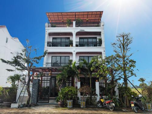a white building with a red roof at EasyLife Villa Hoi An in Tân Thành (1)