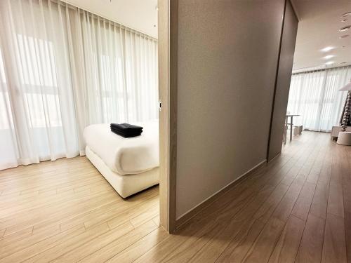 a room with a white bed and a mirror at The November Stay Guri Station in Guri