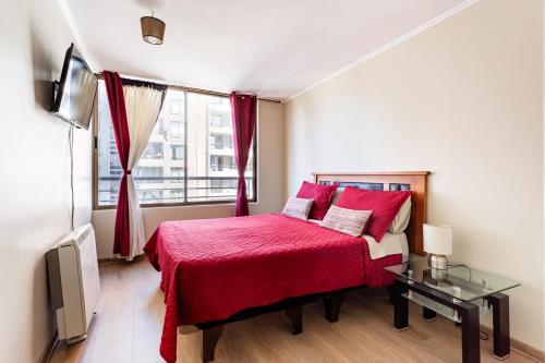 - une chambre avec un lit rouge et une fenêtre dans l'établissement Lindo departamento hasta 6 personas, estacionamiento, à Santiago